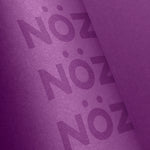 Load image into Gallery viewer, Close-up of the purple Noz sunscreen bottle
