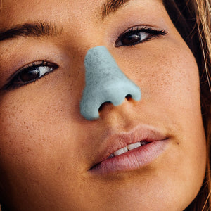 Close-up of a woman wearing the blue Noz sunscreen