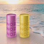 Load image into Gallery viewer, Front view of the purple and yellow Noz sunscreen in front of an ocean
